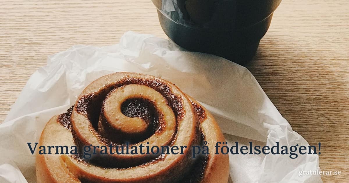 Varma gratulationer på födelsedagen! — Kanelbulle och kaffekopp på träbord — mysig svensk fika